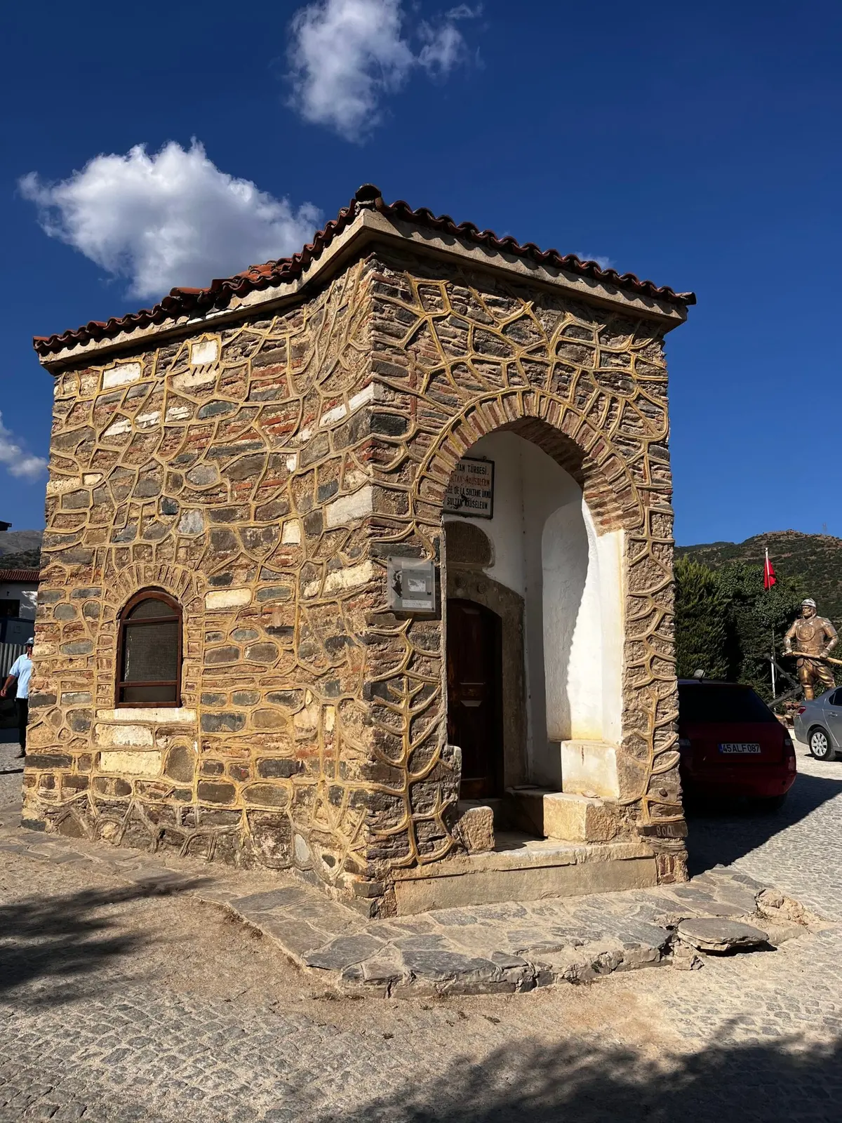 Birgi’de taş duvarlı tarihî bir yapı ve mavi gökyüzü